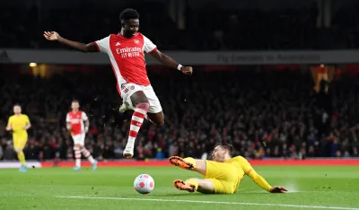 epa09829689 Bukayo Saka (L) of Arsenal in action against Andrew Robertson of Liverpool during the English Premier League soccer match between Arsenal FC and Liverpool FC in London, Britain, 16 March 2022. EPA-EFE/NEIL HALL EDITORIAL USE ONLY. No use with unauthorized audio, video, data, fixture lists, club/league logos or 'live' services. Online in-match use limited to 120 images, no video emulation. No use in betting, games or single club/league/player publications